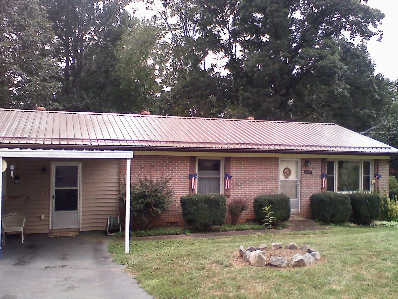 Bronze metal roof and carport on a brick ranch home — Roof Repair work by our crew in Foss